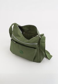 Olivengrøn nylon skuldertaske med lynlåsåbning, justerbar rem, frontlomme og en cirkulær logoaccent. Glat tekstur og struktureret form.