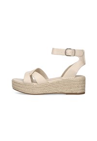 Sandalias de plataforma beige con correas entrecruzadas, hebilla en el tobillo y una suela intermedia estilo esparto tejida. Parte superior de cuero suave con suela plana.