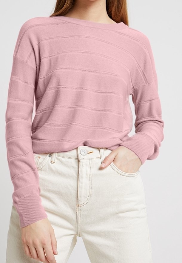 Pullover a righe rosa realizzato in maglia, con scollo ampio e polsini a coste, indossato su jeans bianchi a vita alta con dettaglio di bottoni e tasche.