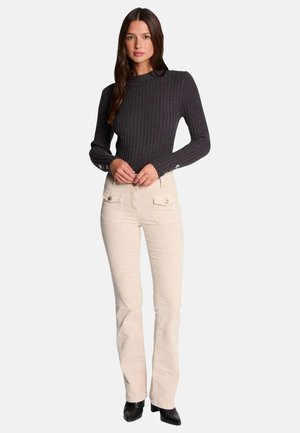 Haut à manches longues côtelé gris foncé avec un col rond et une coupe ajustée, associé à un pantalon flare beige clair avec des poches avant.