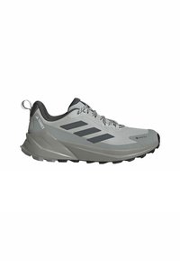 Lichtgrijze wandelschoenen voor buiten met zwarte accenten, een gestructureerde bovenkant, veters en een stevige zool die is ontworpen voor grip. Voorzien van een GORE-TEX-label.