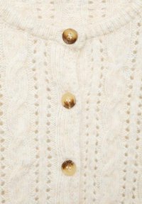 Cárdigan de punto color crema con un patrón de cables, que cuenta con botones redondos de color marrón claro y cuello acanalado. Textura suave, aspecto acogedor.