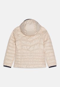 Giubbotto imbottito trapuntato beige chiaro con cappuccio, cuciture a zig zag e orizzontali, e rifiniture nere sui polsini delle maniche, mostrato piatto dal retro.