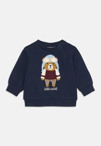 Mörkblå sweatshirt med en broderad björn i pilotkläder med goggles, randiga byxor och texten "liten pilot." Mjukt bomullsmaterial.
