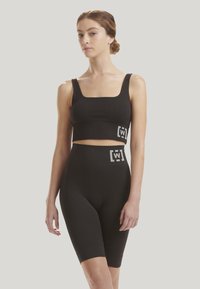 Černý žebrovaný sportovní set s čtvercovým výstřihem, skládající se z crop topu a šortek s vysokým pasem, s logem na pásku a lemu.