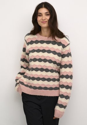 Pull en tricot coloré présentant des rayures en zigzag rose, crème et gris foncé. Texture douce avec un col et des poignets côtelés.