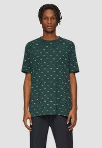 Groene t-shirt met korte mouwen en een wit herhalend tekstpatroon. Losse pasvorm, ronde halslijn, zacht materiaal en rechte zoom.