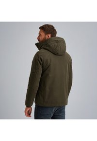 Maslinasto zelena jakna s kapuljačom, s visokim ovratnikom, zatvaranjem na cipzar i ukrasnim šavovima na ramenima i rukavima. Ležerni dizajn.