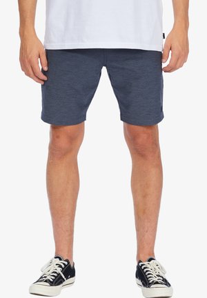 Navy blue fabric shorts with a textured finish, featuring a mid-rise design. Paired with black canvas sneakers and a white t-shirt.