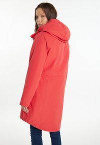 Rød hættejakke med indsnævret talje, lange ærmer og sidelommer. Glat tekstur og knælangt design.