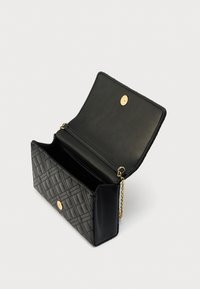 Μαύρη τσάντα χειρός από δερματίνη με σχέδιο καπιτονέ, χρυσά μεταλλικά στοιχεία, λουράκι αλυσίδα και μαγνητικό κλείσιμο. Στο εσωτερικό περιλαμβάνει μία θήκη.