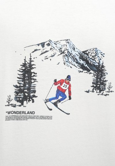 T-shirt de tecido branco com um esquiador vestido de vermelho e azul, número 25 no peito, contra um cenário montanhoso nevado com árvores perenes.