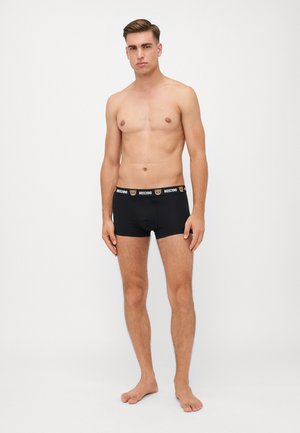 Schwarze Boxershorts mit einem Logo-Bund und Bärengrafiken. Das Material wirkt weich und elastisch und sorgt für eine figurbetonte Passform.