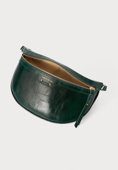 Borsa in pelle verde con forma curva, hardware dorato, chiusura a zip e un interno tan a contrasto. Presenta un logo del marchio e una tracolla sottile.