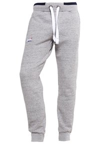 Graue Jogginghose aus weichem Baumwollmischgewebe, mit Kordelzug, geripptem Bund und Bündchen an den Knöcheln. Dezentes Logo am Bein.