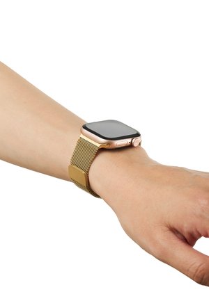 Smartwatch med et gyldent mesh-armbånd båret på venstre håndled, skærm slukket mod en hvid baggrund.