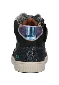 Sneaker alta nera con dettagli iridescenti, collo peloso e superficie testurizzata con una leggera lucentezza. Dettaglio con codice a barre sul tallone.