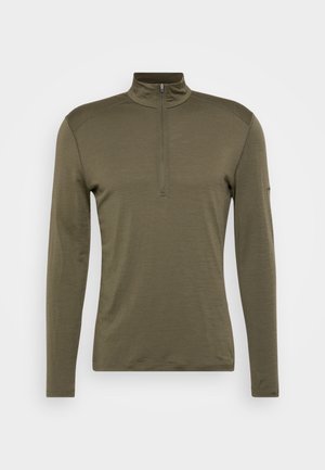 Olivenfarget langermet skjorte med halv glidelås i kragen, laget av mykt stoff med en jevn tekstur og minimale sømdetaljer.