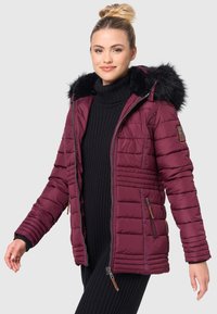 Giubbotto imbottito bordeaux con cappuccio in pelliccia sintetica nera, tasche laterali con zip, polsini a coste e una silhouette snella. Tessuto testurizzato.