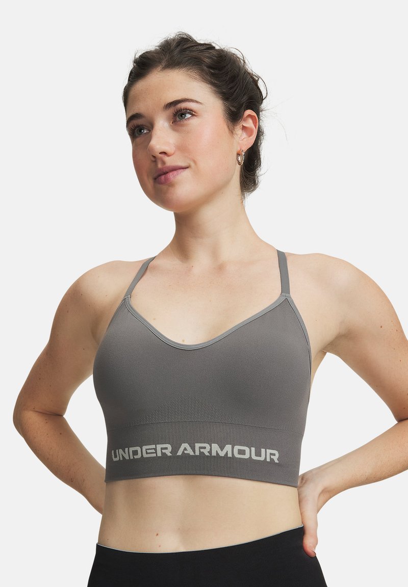 Γκρι αθλητικό σουτιέν με λεπτές τιράντες, λαιμόκοψη σε σχήμα U και υφασμένο κάτω μέρος με την επιγραφή "UNDER ARMOUR" σε ανοιχτό γκρι.