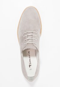 Scarpa in suede grigio chiaro con punta arrotondata, lacci bianchi e suola color naturale. L'interno presenta un'etichetta del marchio e la taglia.