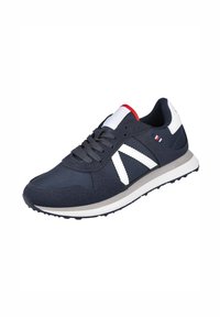 Zapatilla deportiva azul marino con rayas blancas, tejido texturizado y suela blanca. Presenta detalles en rojo y blanco en la lengüeta y el lateral.