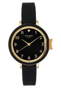 Reloj negro redondo con acentos en oro, que presenta una esfera negra, números en negrita y una correa de silicona para mayor comodidad. Nombre de la marca mostrado en la esfera.
