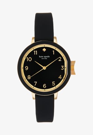 Okrągły czarny zegarek ze złotymi akcentami, z czarną tarczą, wyraźnymi cyframi i silikonowym paskiem dla komfortu. Nazwa marki widoczna na tarczy.