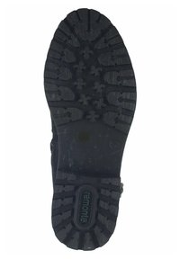 Semelle de chaussure en caoutchouc noir avec un motif de semelle rugged. Comprend des rainures profondes et des motifs en croix surélevés pour une meilleure traction. Détail de marque circulaire inclus.