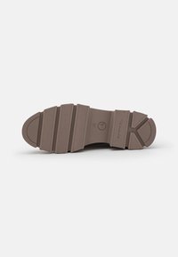 Brown rubber shoe sole with a textured surface, featuring segmented grooves and rounded ends for enhanced grip and flexibility.
