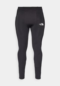 Svarta atletiska leggings i elastiskt material med en åtsittande passform. Har en sidoficka och en reflekterande logotyp nära midjan.