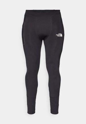 Black athletic leggings made of stretchy material with a snug fit. Features a side pocket and reflective logo near the waistband.