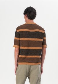 Gebreide trui met korte mouwen, gekenmerkt door afwisselende bruine en beige strepen, een ronde halslijn en ribgebreide mouwen, met een gestructureerde stof.