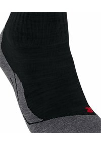 Calcetín negro y gris con textura acanalada, acentos de acolchado y un detalle de logo rojo cerca del tobillo. Presenta un diseño de materiales mixtos.