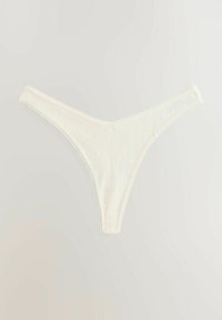White lace thong with vertical stripe pattern, thin waistband, soft texture, and decorative stitching along the edges.