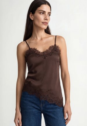 Braunes Satin-Camisole mit Spitzenbesatz am Ausschnitt und Saum, ausgestattet mit dünnen verstellbaren Trägern und gerader Silhouette. Kombiniert mit blauen Jeans.