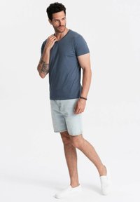 Pánské tričko s krátkým rukávem, námořnická modrá, bavlněné, v kombinaci s lehkými džínovými šortkami a bílými slip-on botami. Jednoduchý design a volný střih.