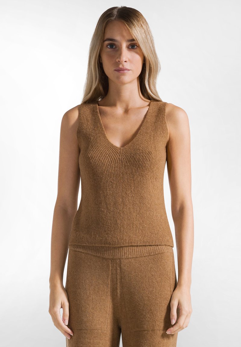 Bruine geribbelde gebreide mouwloze top met een V-hals, met een aansluitend ontwerp en een zachte textuur, gecombineerd met bijpassende onderkleding.