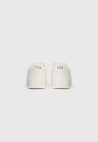 White leather sneakers with a textured finish, featuring a round toe and flat rubber soles. "Jack & Jones" logo embossed on the heel tab.