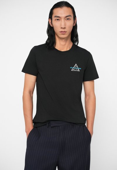 Melna kokvilnas T-krekls ar apaļu kaklu un īsām piedurknēm. Uz krūtīm ir balta un zila kalnu grafika.