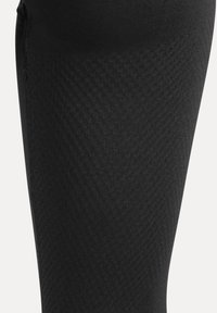 Schwarze Kompressionsleggings mit strukturiertem Diamantmuster, glattem Material und Flatlock-Nähten für zusätzlichen Komfort und Langlebigkeit.