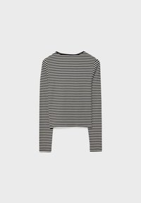 Crno-bijeli prugasti dugosleeve crop top s okruglim izrezom. Izrađen od mekog materijala, ima kontinuirane horizontalne pruge.