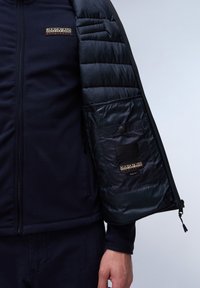 Dunkelblauere Jacke mit einem Fleece-Außenmaterial und einem gesteppte Innenfutter. Verfügt über einen Reißverschluss, ein Logo-Logo-Patch sowie eine Innentasche mit Druckknopf.