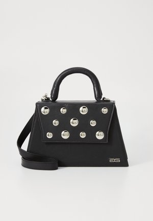 Črna torbica s strukturirano obliko, ki ima zgornjo ročico, naramnico in dekorativne kovinske žeblje na sprednji strani.