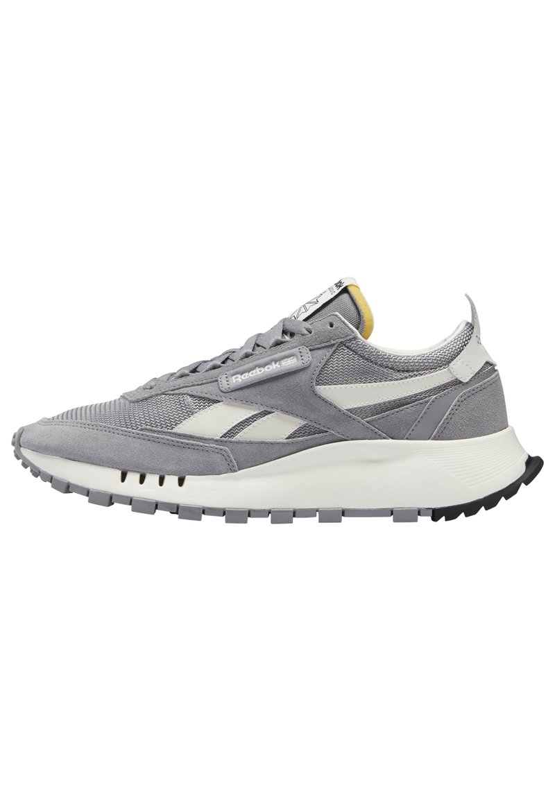 Baskets Reebok grises et blanches avec empeigne en daim et mesh, design à lacets, semelle rembourrée et semelle extérieure crantée, affichées en vue de profil.