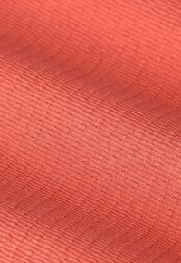 Gestructureerde stof in een koraalkleur, met een subtiel diagonaal ribpatroon en een gladde oppervlakte met een lichte glans.