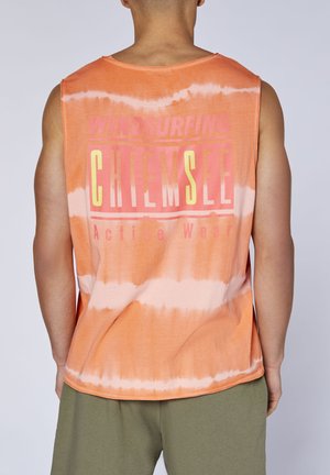 Mann trägt orange gefärbtes ärmelloses Oberteil mit dem Schriftzug „WINDSURFING CHIEMSEE Active Wear“, kombiniert mit olivgrüner Hose, von hinten betrachtet.
