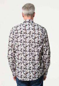 Langermige shirt in een bloempatroon met tinten zwart, beige en grijs. Gemaakt van lichte stof met een klassieke kraag.