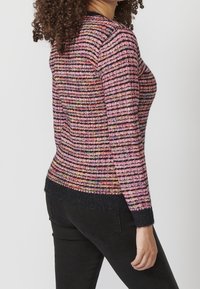Pull en maille avec rayures horizontales multicolores en rose, violet et noir. Comprend un ourlet et des poignets côtelés en bleu marine foncé.