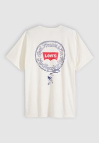 T-shirt en coton blanc avec un motif imprimé bleu encadré d'une bordure en corde et un logo Levi's rouge au centre. Manches courtes et coupe standard.